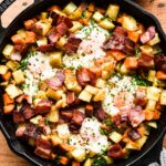 Close up of breakfast skillet with eggs, bacon, and potatoes.