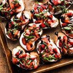 Strawberry Balsamic Crostini on a sheet tray with basil on top