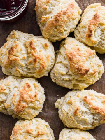 Drop Biscuits on parchment paper with jam in the corner.