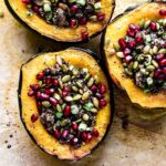 Stuffed acorn squash topped with pomegranate seeds and pepitas.