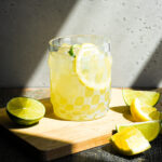 lemon lime margarita in a glass with lime and lemon slices.