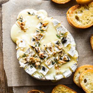 Overhead zoomed in image of baked camembert cheese with crostini.