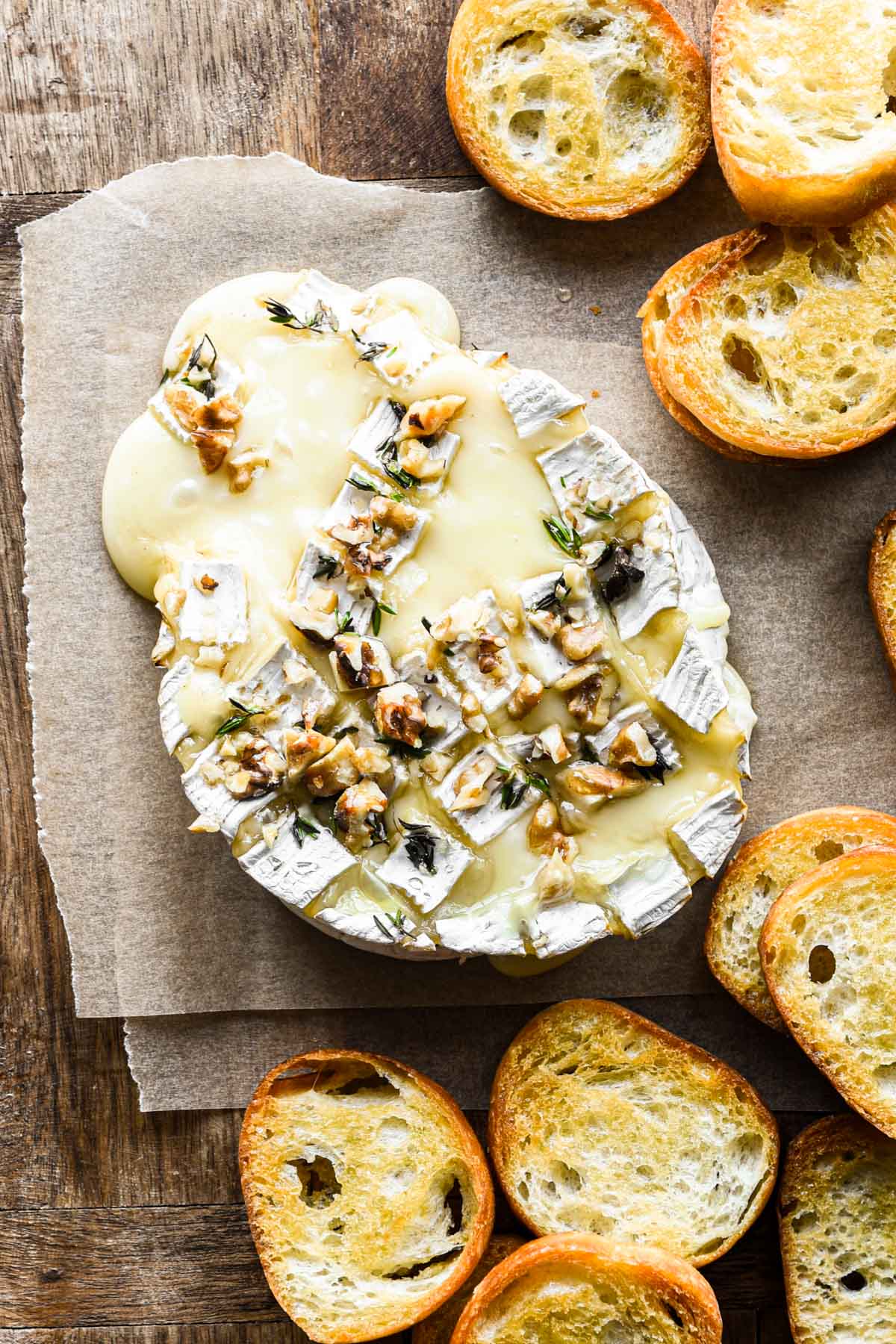 Overhead image of baked melty camembert cheese with crostini.
