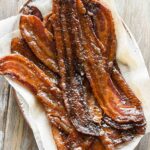 close up image of maple candied bacon on a plate.