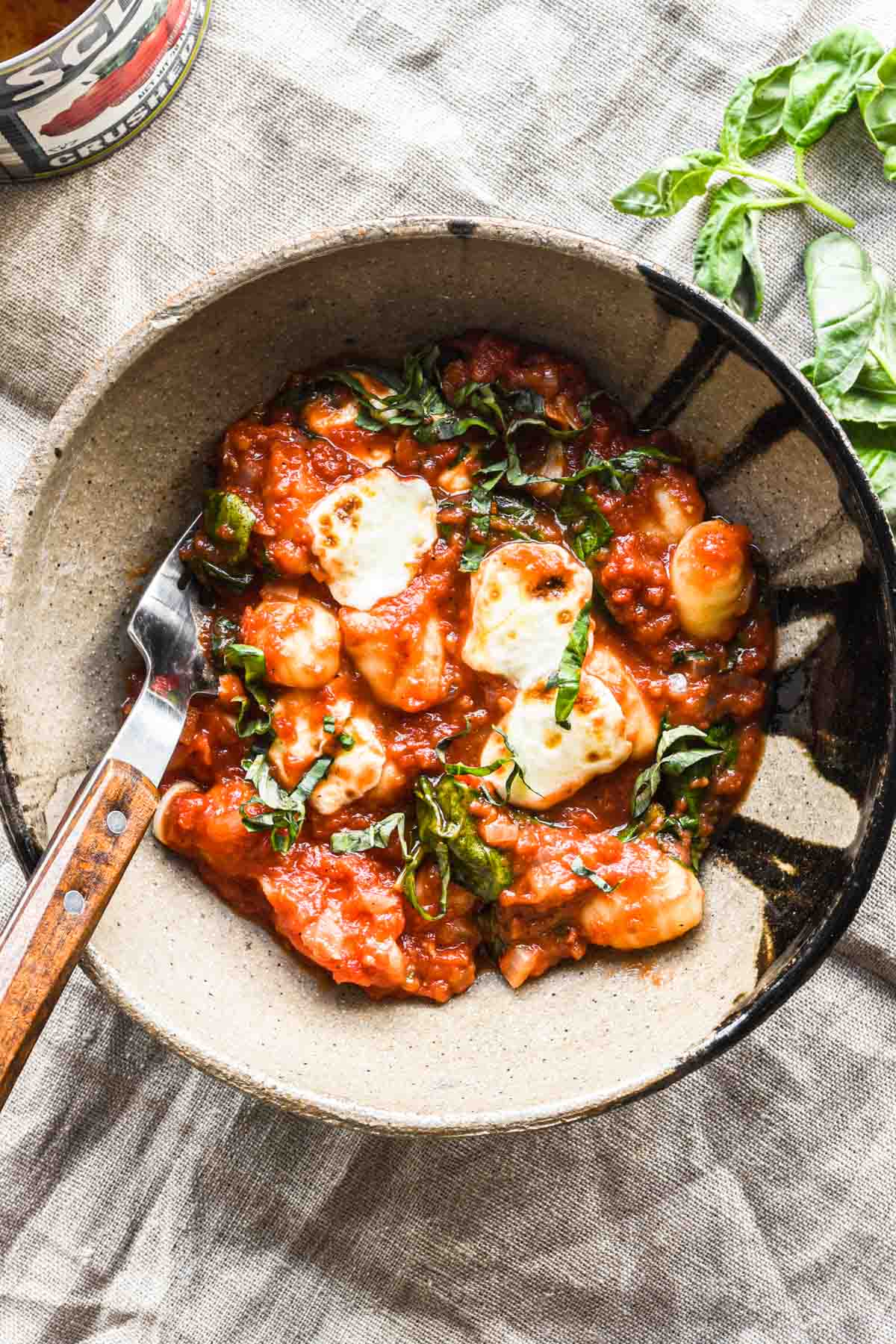 Serving of gnocchi in a bowl with basil.