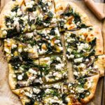 Close up of sliced spinach and feta pizza.
