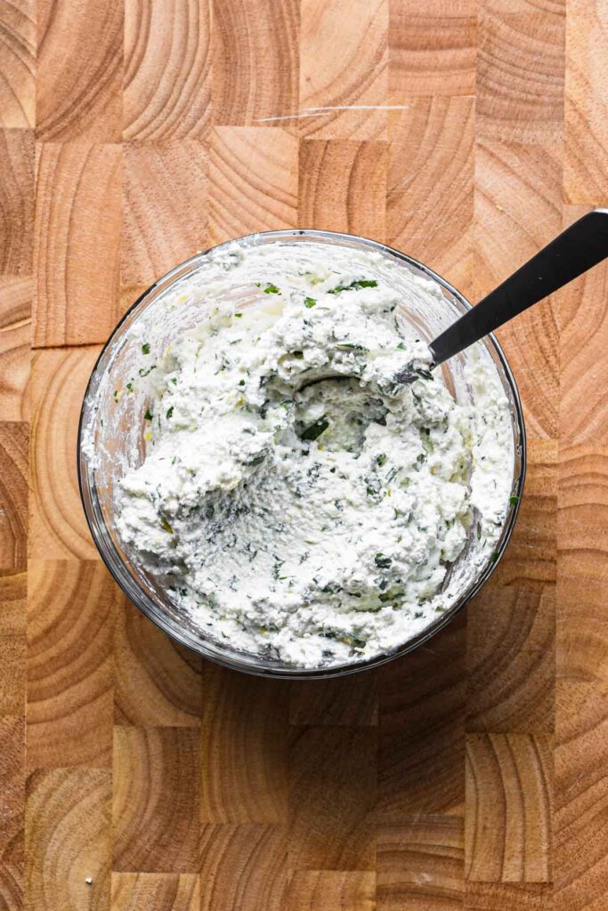 Herb ricotta mixture in a bowl.
