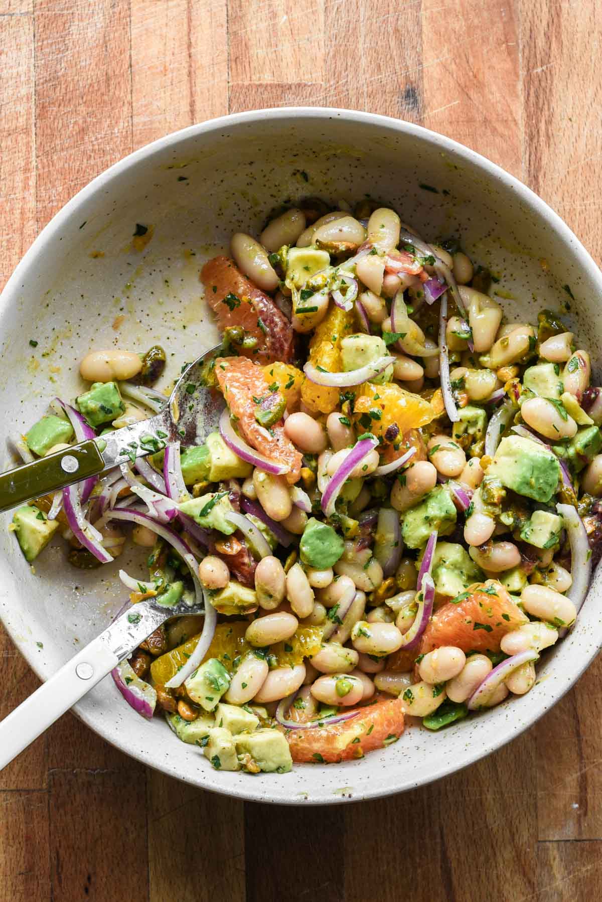 White bean citrus salad being eaten out of a big bowl.