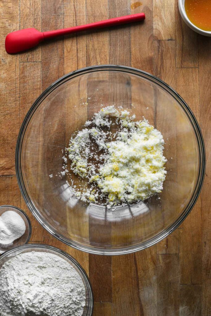 Mixing sugar and lemon zest in a bowl.