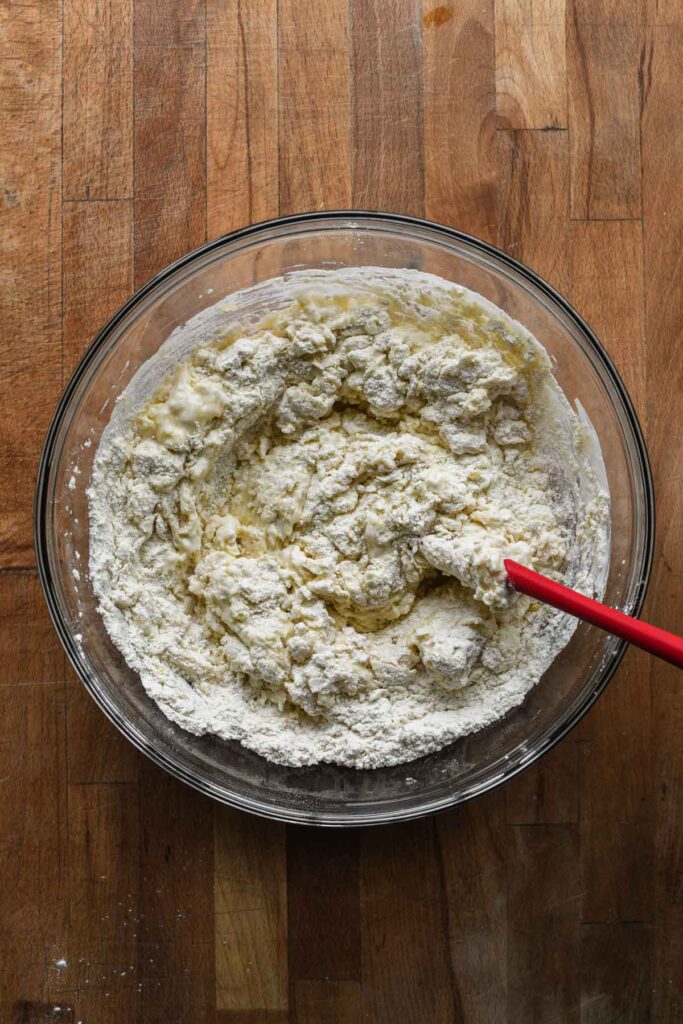 Mixing in wet ingredients with a rubber spatula.