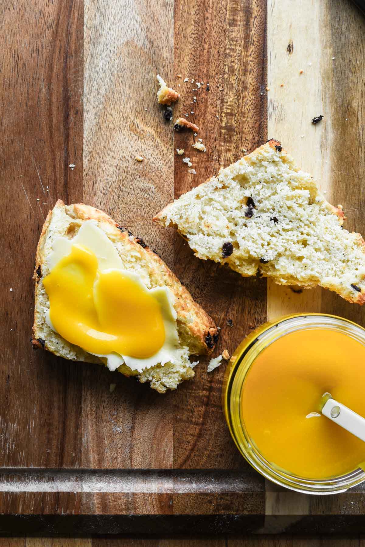 Passion fruit curd on a scone with butter.