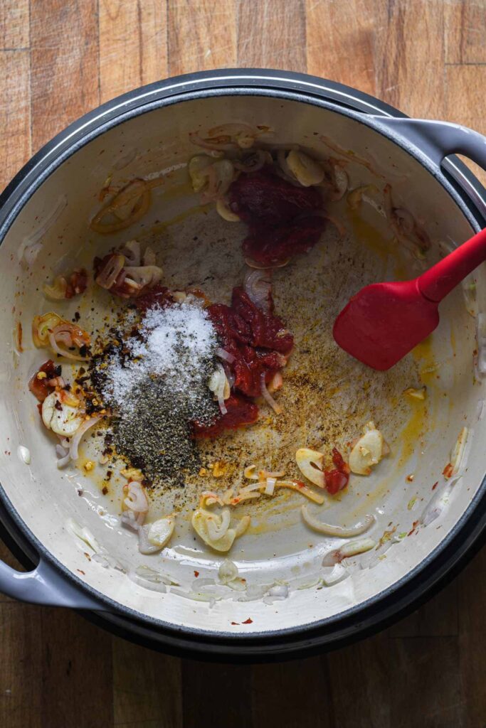 Adding tomato paste and spices.