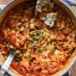 Close up of tomato beans with cheese, oregano and bread.
