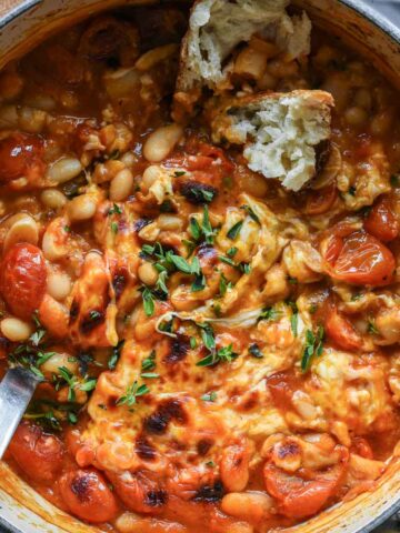 Close up of tomato beans with cheese, oregano and bread.