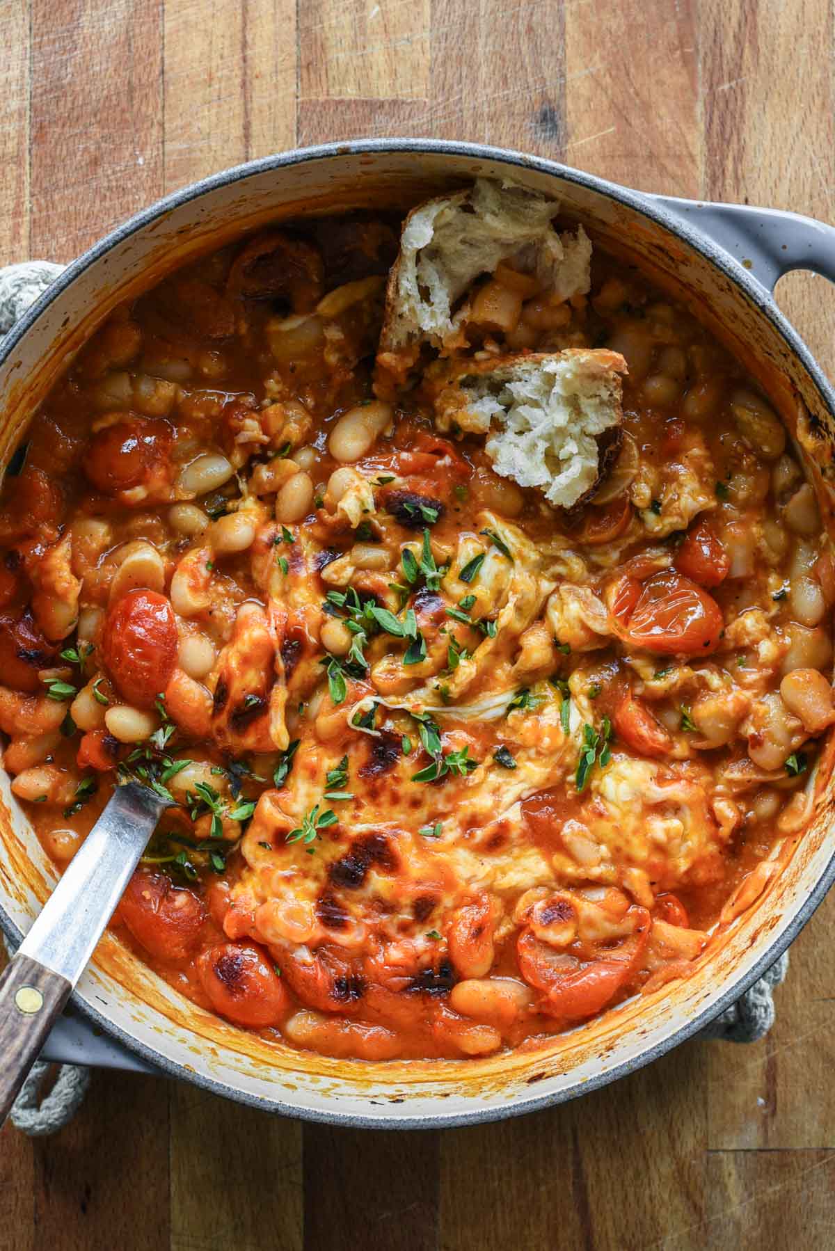 Close up of tomato beans with cheese, oregano and bread.