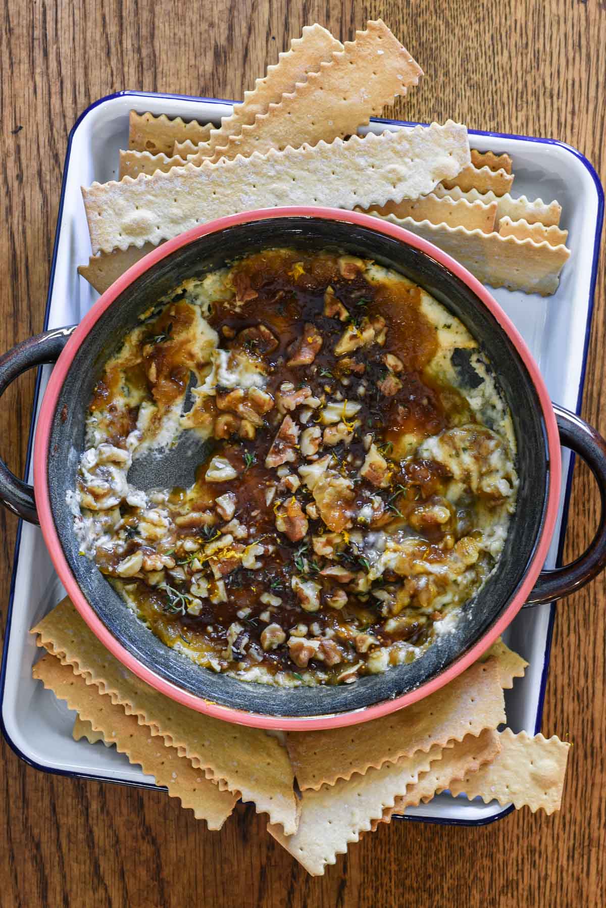 Boursin dip with jam on a tray with crackers around it ready for serving.